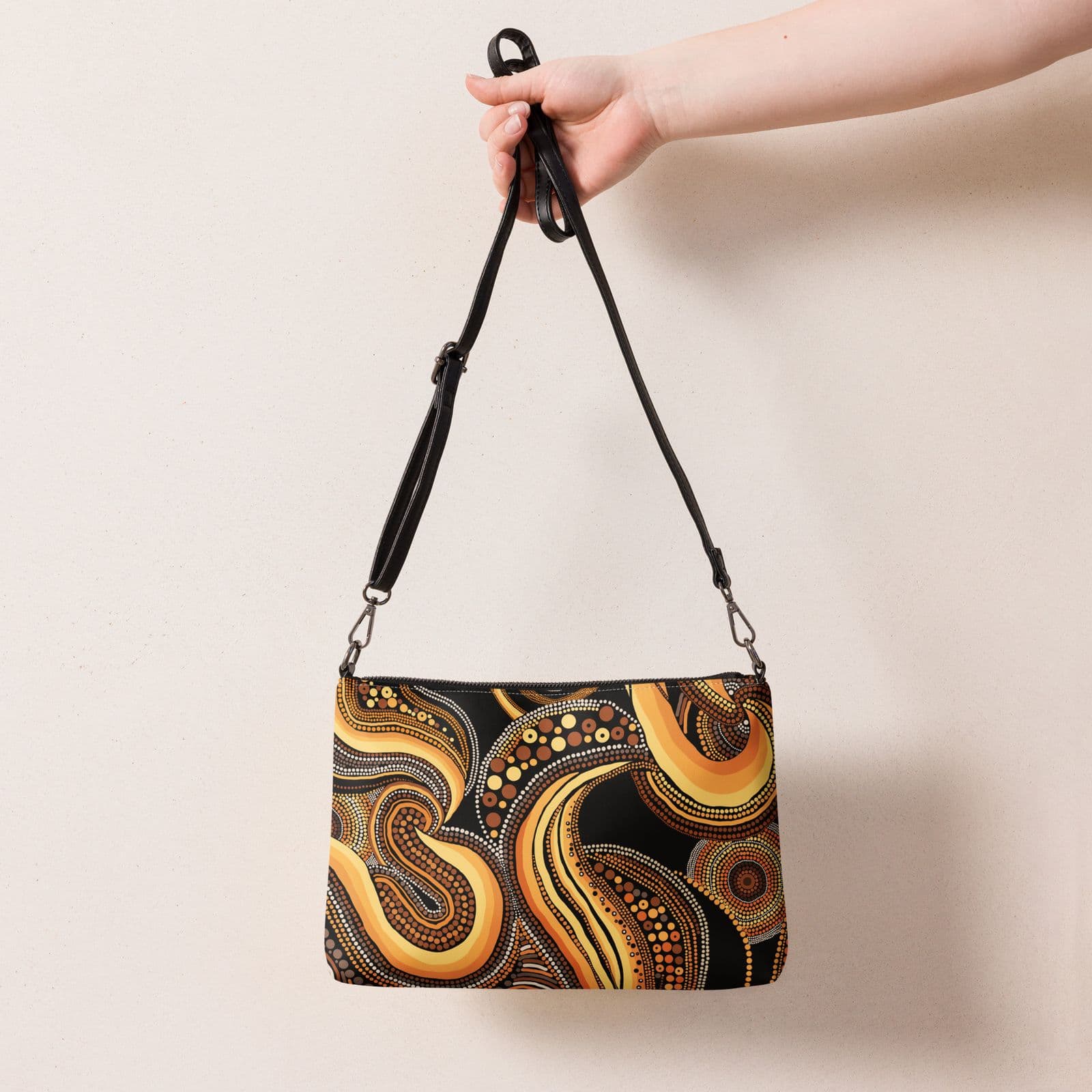 The Desert Rhythms Crossbody Bag held by its shoulder strap